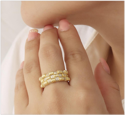 Anillo dorado de múltiples hileras con incrustaciones brillantes
